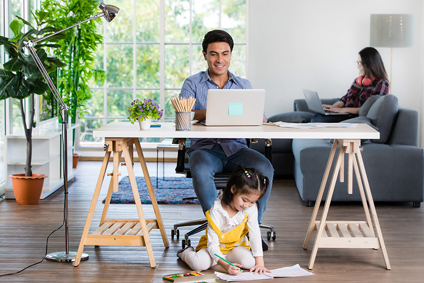 Hispanic father and mother working from home with daughter playing on the floor