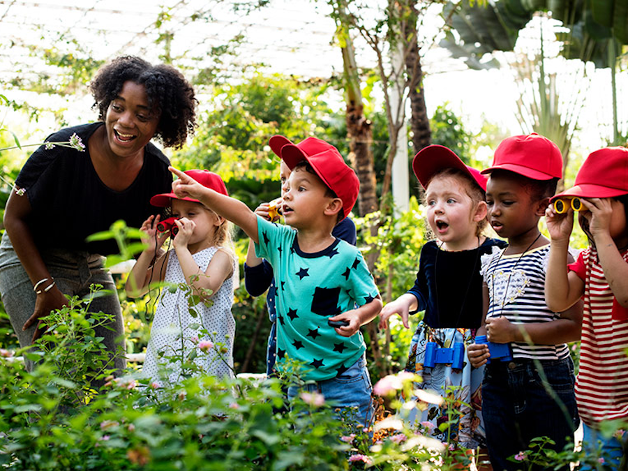 African American woman with group of diverse children at a farm