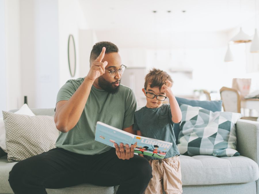 Boy learning sign language from adult.