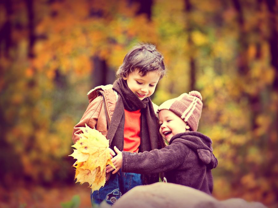 Children laughing and playing with leaves.