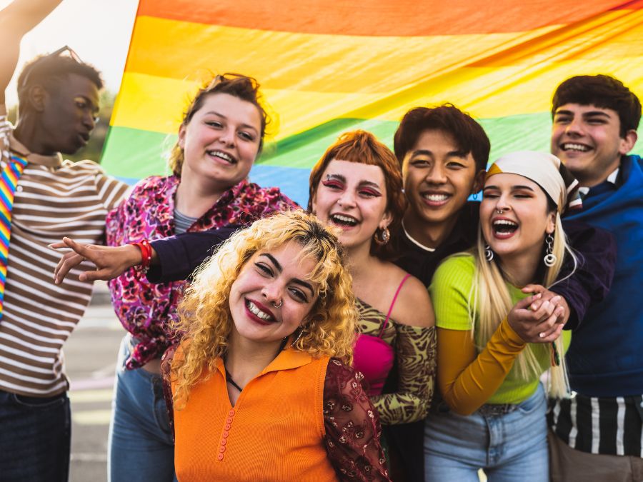 Group of teens with a pride flag.