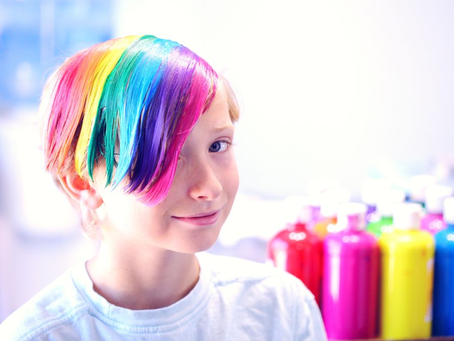 Youth with hair painted in rainbow colors.