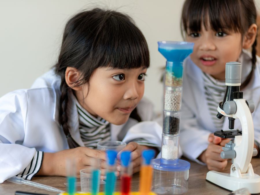 Two young girls learning science with lab equipment.