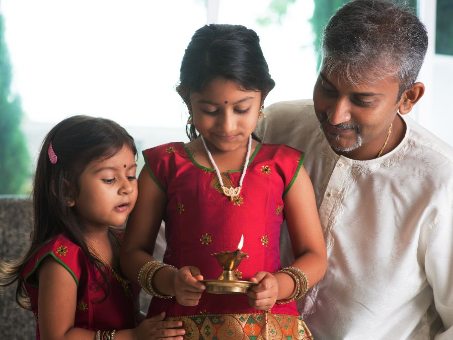 Two children and their father celebrating Diwali.