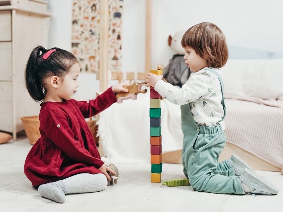 Two children playing with blocks and wooden toys.