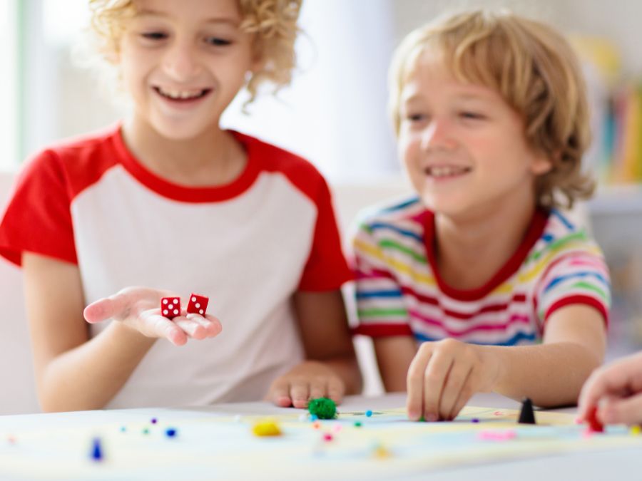 Two children playing with six sided dice.