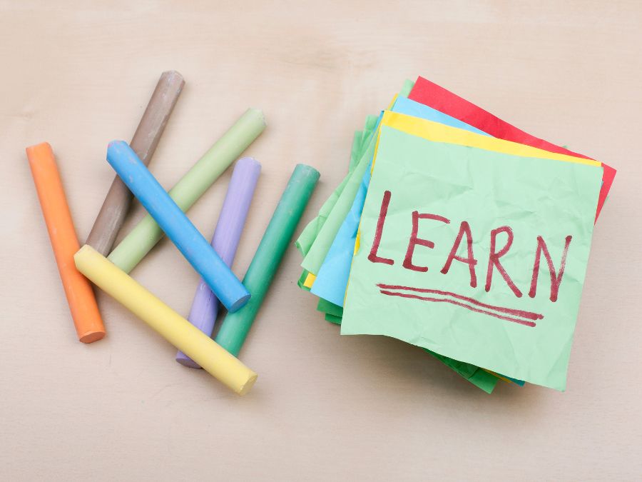 Collection of colorful chalk and a note that reads "LEARN"