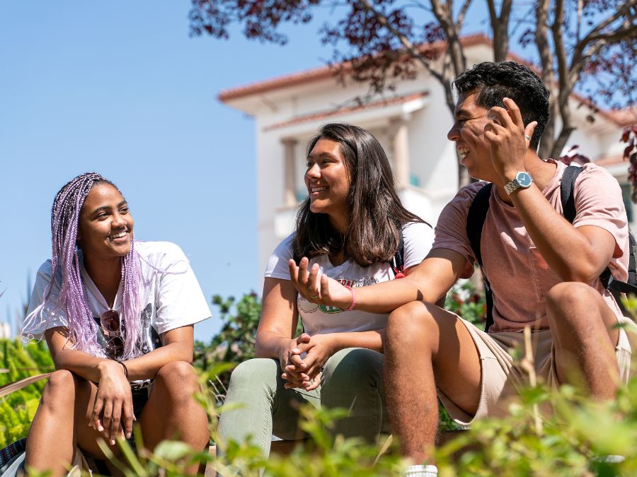 SDSU students sitting on the lawn talking.