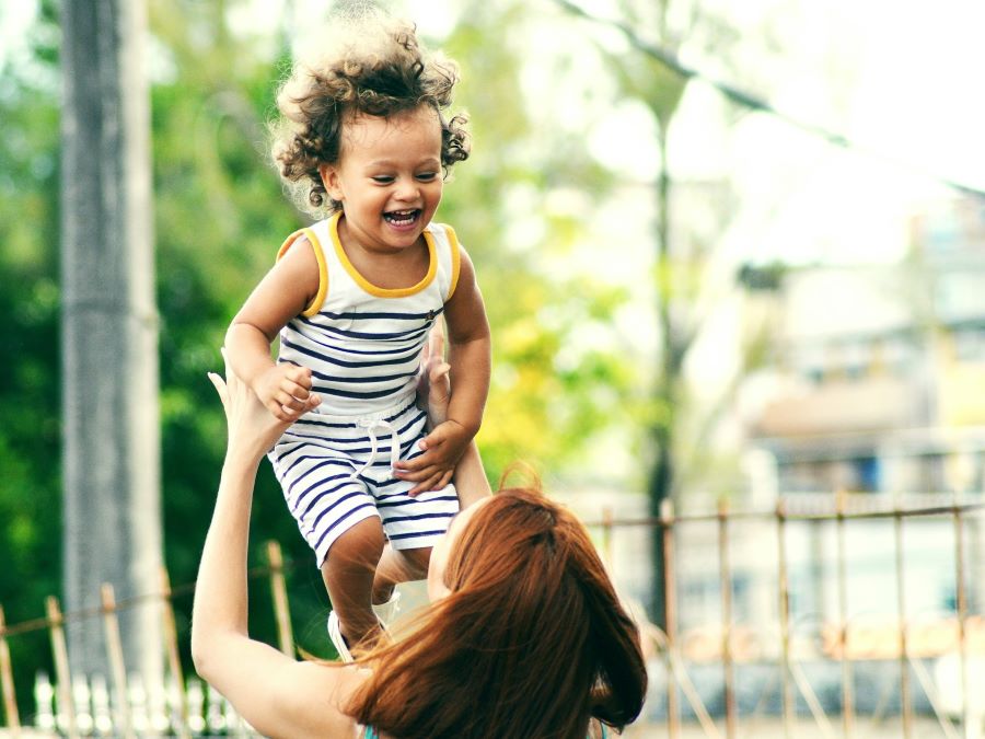 Parent lifting child up in the air.