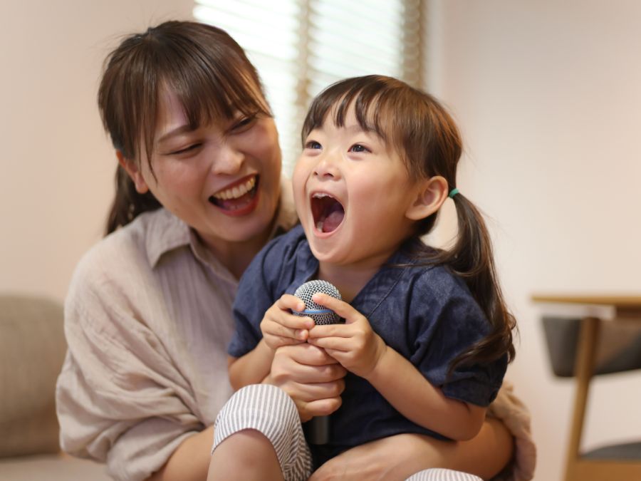 Parent and child laughing and sitting together.