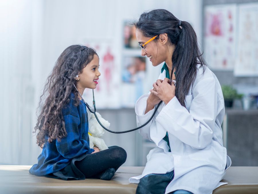Young patient listening to doctors heartbeat.