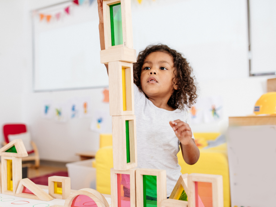 Young child playing with wooden building blocks.