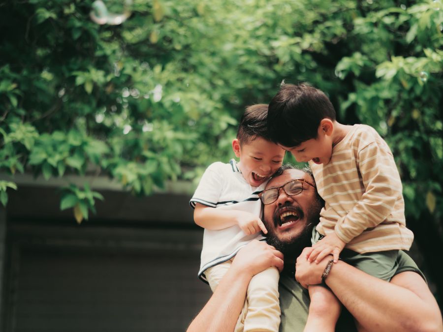 Father holding two children on his shoulders.